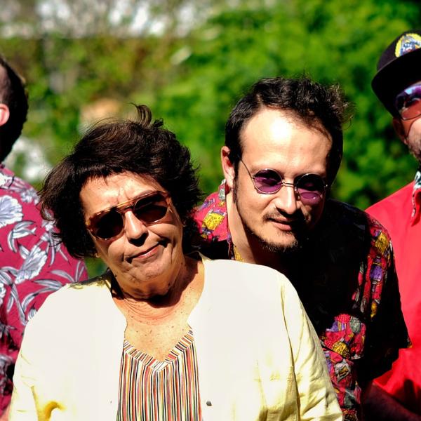Le groupe est dehors et porte des lunettes de soleil. 