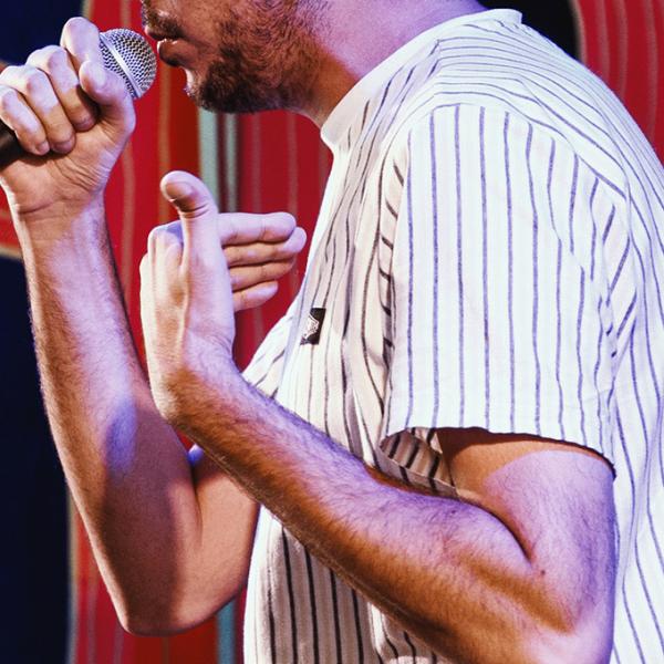 Photo coupée d'un participant à l'Open Mic du Kiwi qui est en train de chanter.