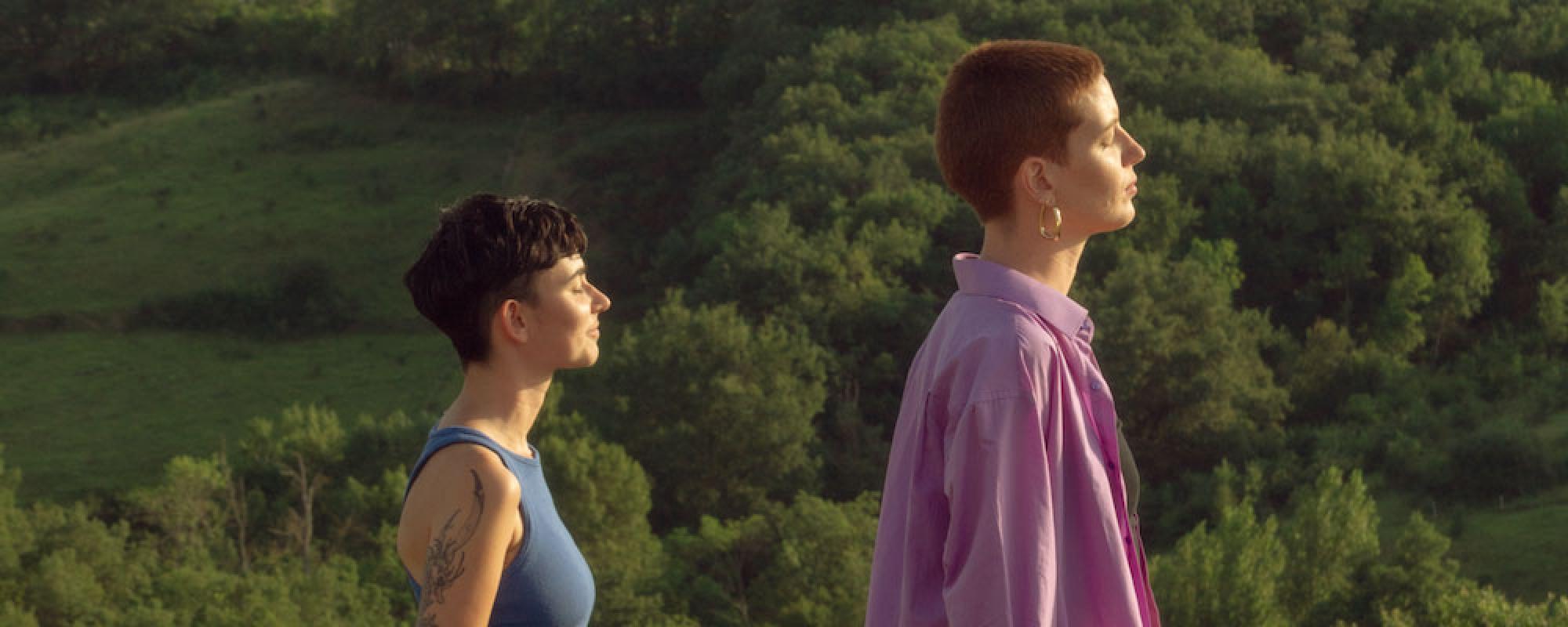 Les deux chanteuses sont dans un chant, tournées vers le soleil, yeux fermés.