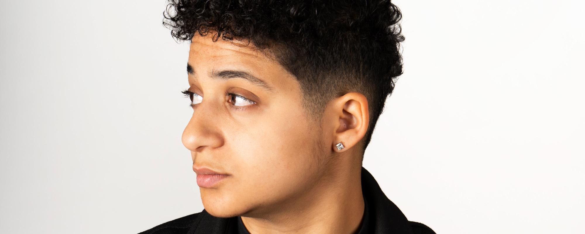 Le visage de la chanteuse, de profil, tournée vers la gauche. Elle a les cheveux courts et porte une boucle d'oreille.